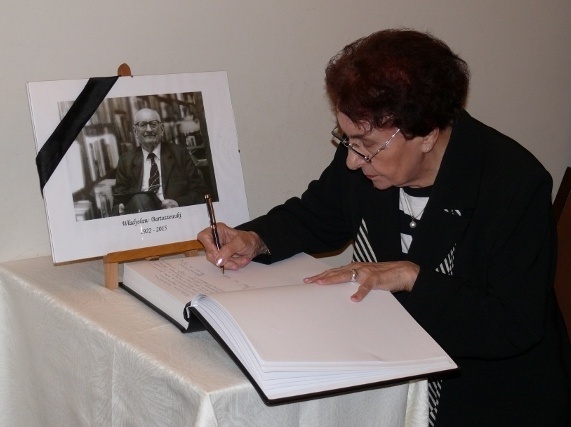 Prof. Dorota Simonides wpisuje się do księgi kondolencyjnej