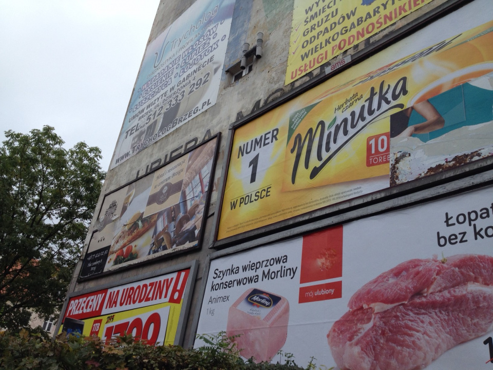 Reklamy na ścianie kamienicy na rogu ulic Chrobrego i 3 Maja [fot. Maciej Stępień]