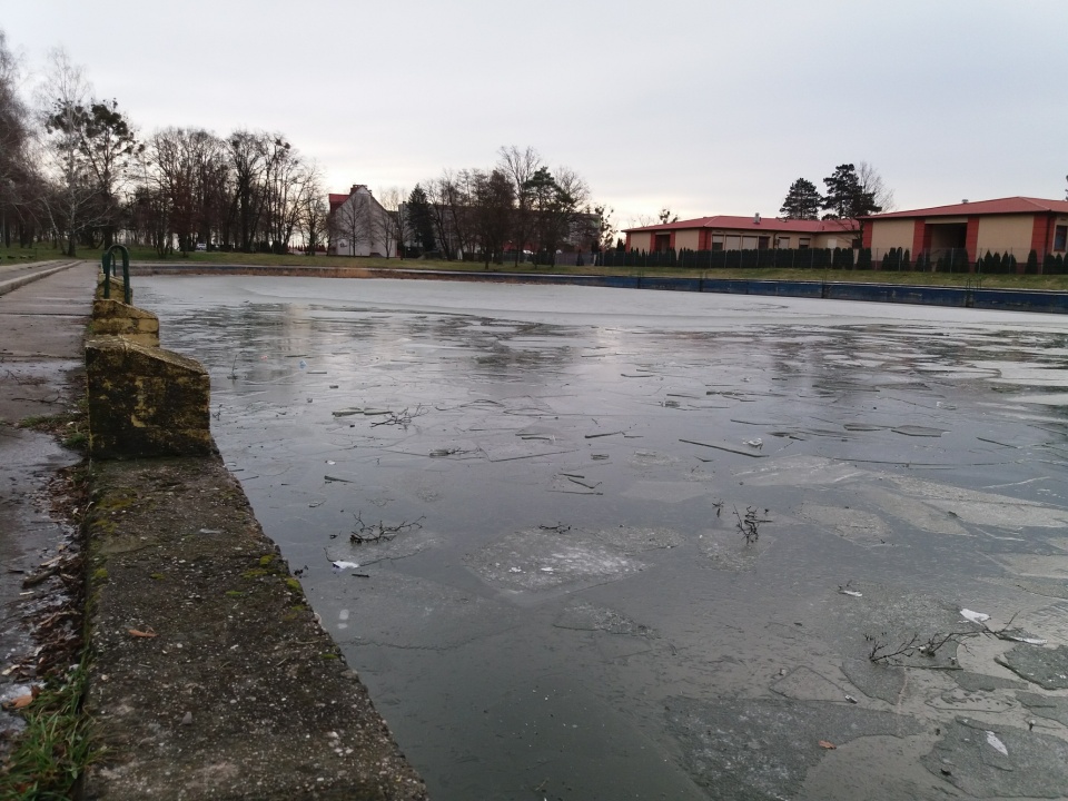 Nieczynny basen w Skarbimierzu Osiedle. W styczniu utonął tu 14-latek, pod którym załamał się lód. Dziś z wody wyciągnięto ciało kobiety [fot. Maciej Stępień]