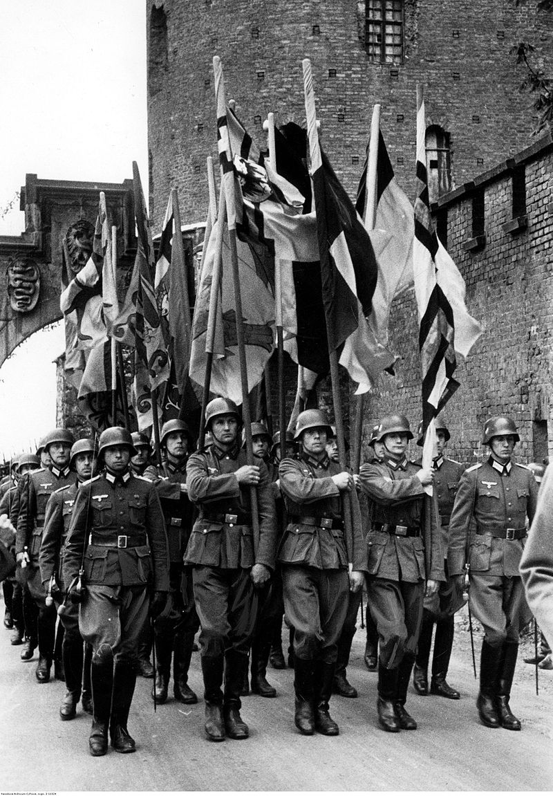 Wyprowadzenie kopii chorągwi krzyżackich zdobytych pod Grunwaldem z Zamku Królewskiego na Wawelu przez żołnierzy Wehrmachtu w 1940 roku [www.Nac.gov.pl]