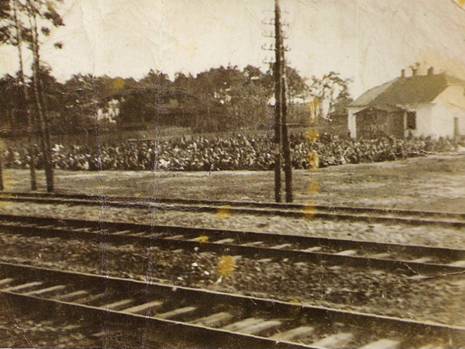 Żydzi otwoccy oczekujący na transport do obozu zagłady w Treblince 19 sierpnia 1942. Zdjęcie wykonano z przejeżdżającego pociągu [fot. wikipedia.pl]