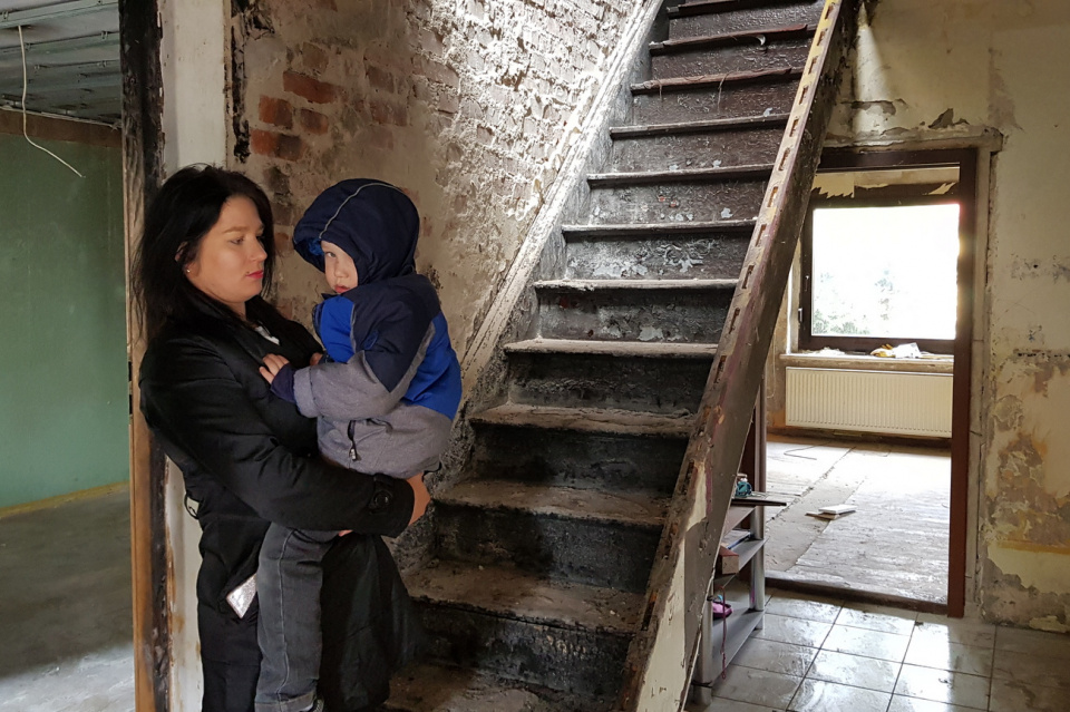 Paulina Sładek-Chlopecka z synem przy schodach, które jej teść oblał benzyną i podpalił [fot. A. Pospiszyl]