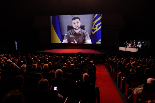 Prezydent Ukrainy Wołodymyr Zełenski pojawia się na ekranie podczas ceremonii otwarcia 75. dorocznego Festiwalu Filmowego w Cannes w Cannes we Francji [fot. EPA/CLEMENS BILAN.: PAP/EPA]