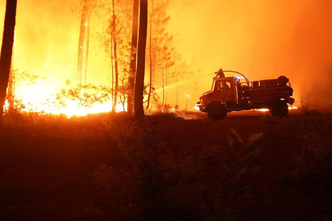 Zdjęcie udostępnione przez wydział komunikacji straży pożarnej Gironde SDIS33 pokazuje strażaków walczących nocą z pożarem lasu w pobliżu Hostens, w regionie Gironde w południowo-zachodniej Francji [fot. PAP/EPA/HANDOUT/SDIS 33 HANDOUT]