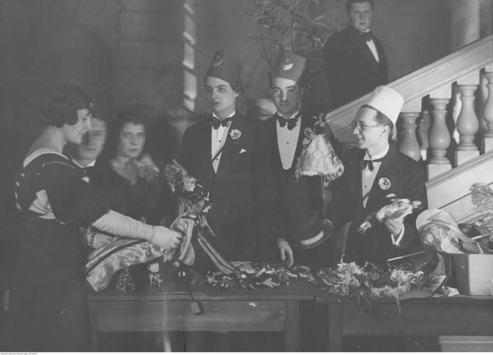 Grupa uczestników balu przy stole z kotylionami. Warszawa luty 1933 [fot. Narodowe Archiwum Cyfrowe]