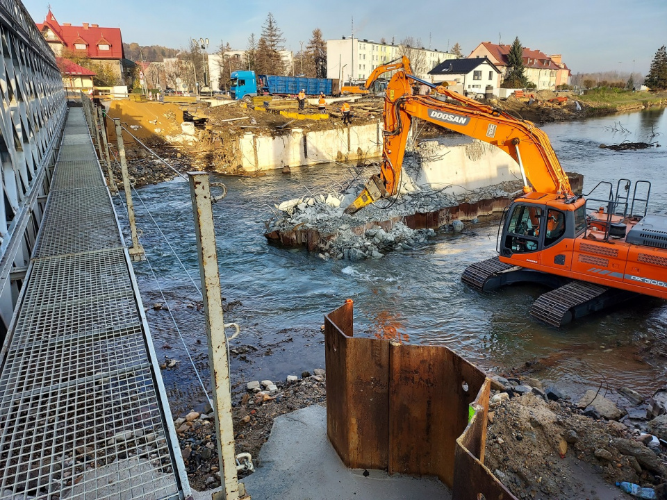 Spotkanie w Głuchołazach zwołano nieopodal tymczasowej przeprawy. Obok niej trwają praca rozbiórkowe zniszczonej przez powódź konstrukcji docelowego mostu na Białej Głuchołaskiej [fot. Jan Poniatyszyn]